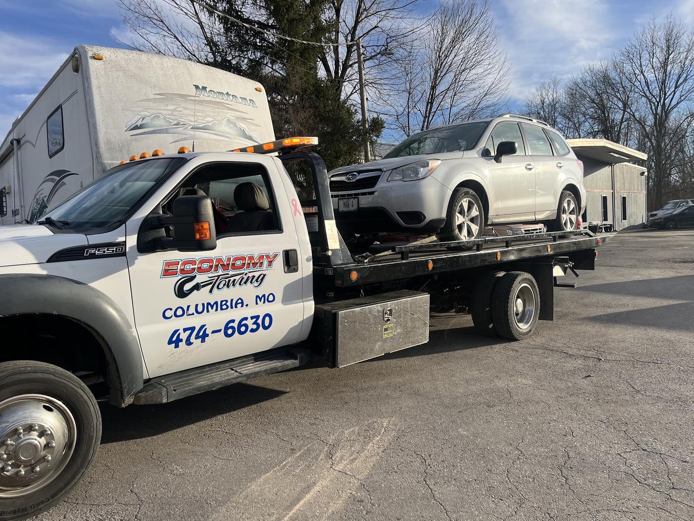 Economy Towing flatbed with an SUV loaded and strapped down